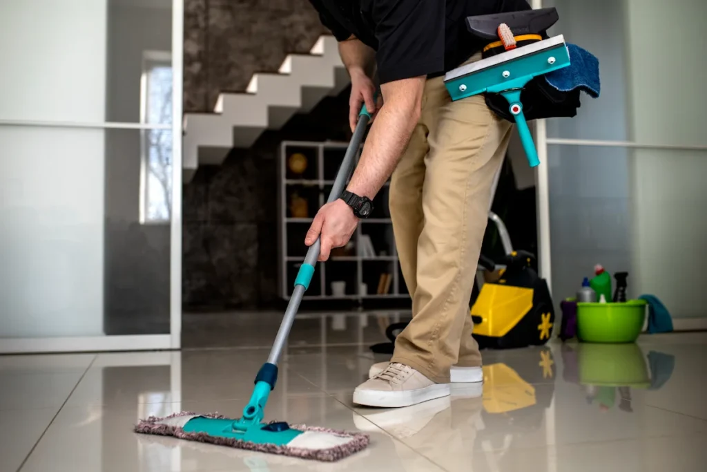 Professional floor cleaning with mop and tools in modern interior