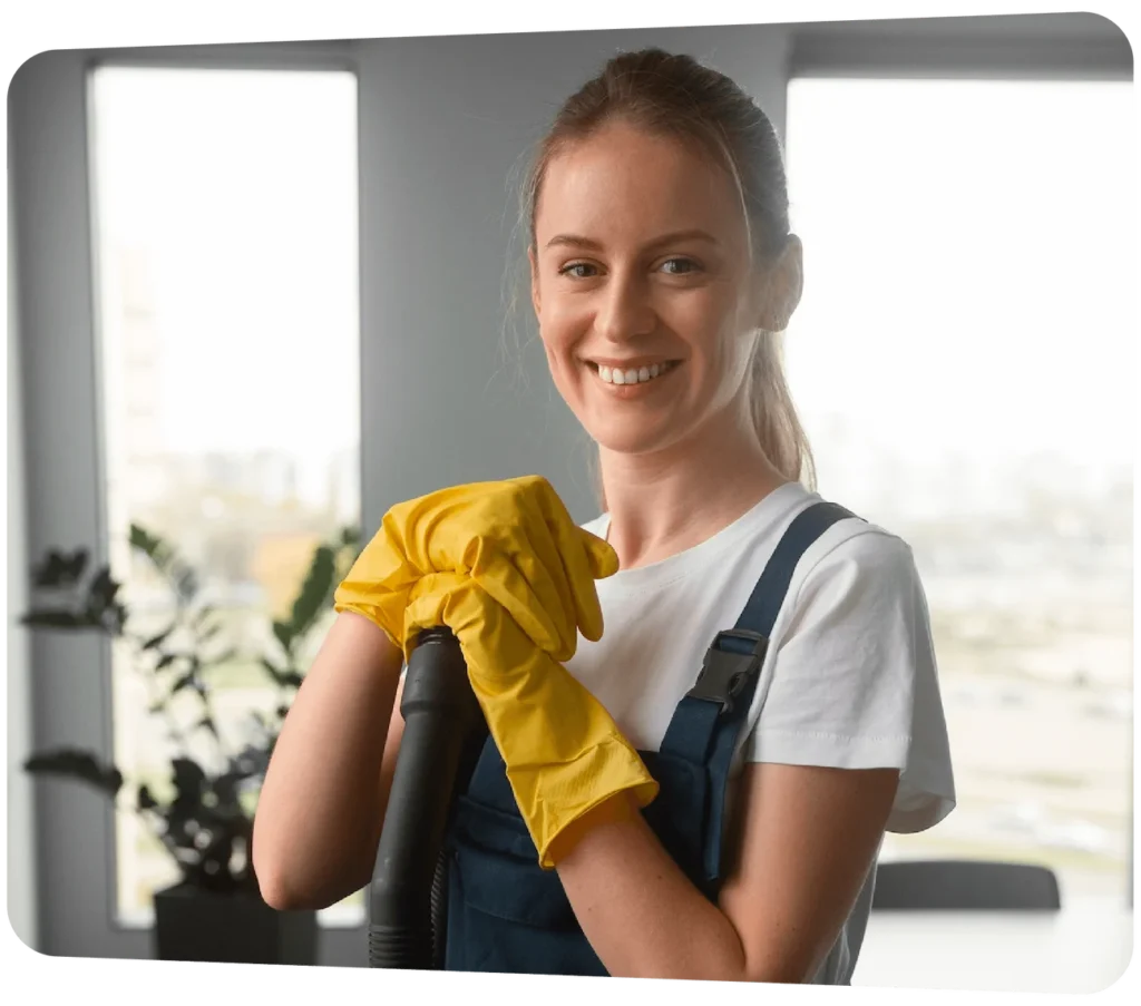 Smiling female cleaning staff wearing gloves in uniform